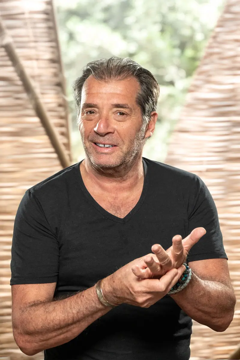 Illustration d'un homme aux bras croisés, légèrement souriant, au style semi-réaliste, représentant un professionnel de la réflexologie plantaire dans une ambiance apaisante.